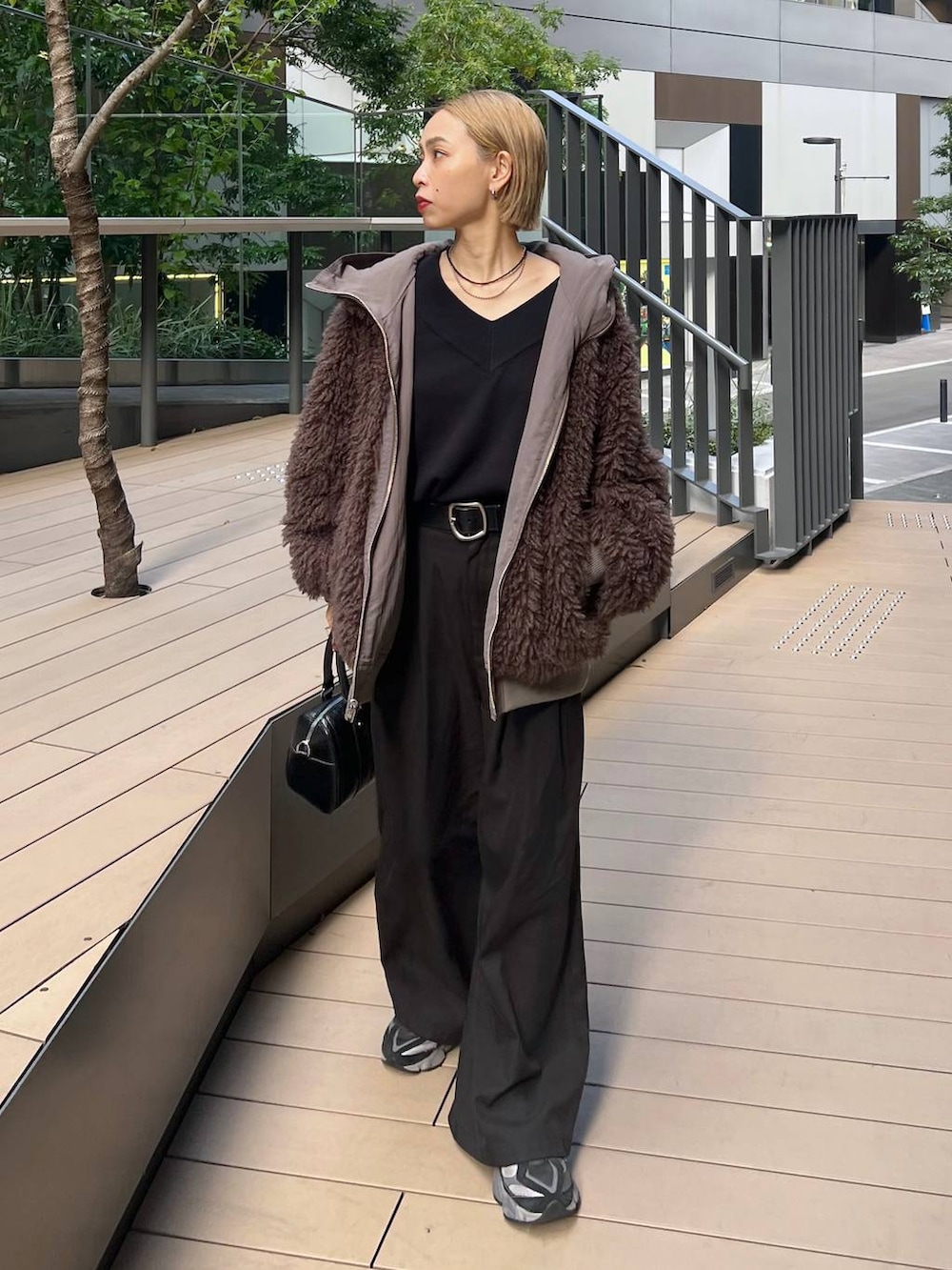 ブラウン系のブルゾン、ブラック系のニット/セーターを着用したレディースの秋コーディネートの2枚目の写真