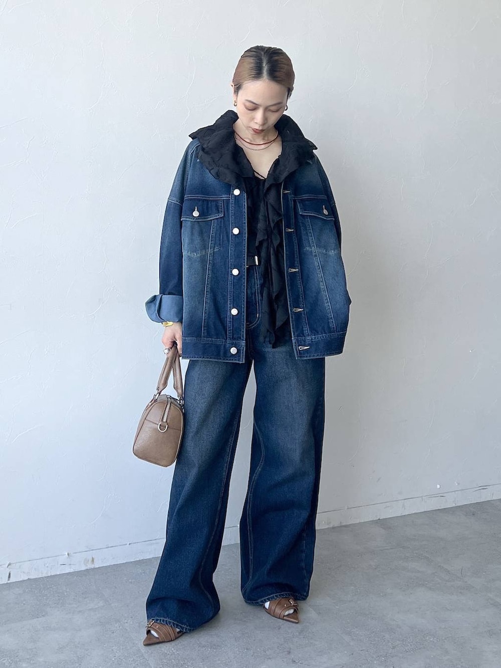 ブルー系のスラックス、ブラウン系のボストンバッグ、ブルー系のブルゾンを着用したレディースの春コーディネートの2枚目の写真