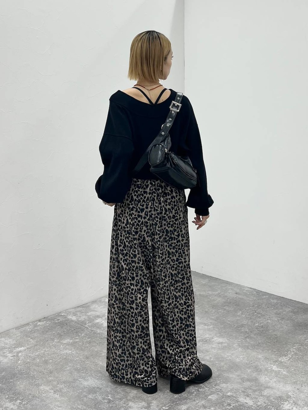 ブラック系のその他シューズ、ブラック系のニット/セーター、ブラック系のショルダーバッグを着用したレディースの秋コーディネートの5枚目の写真