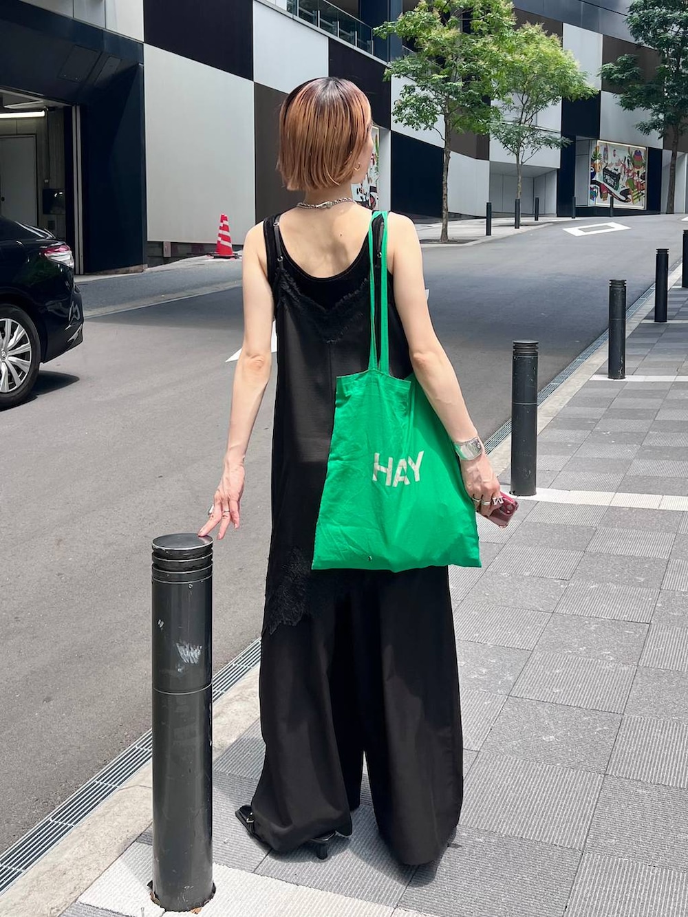 ブラック系のチュニック、ブラック系のスラックス、ブラック系のタンクトップを着用したレディースの夏コーディネートの7枚目の写真