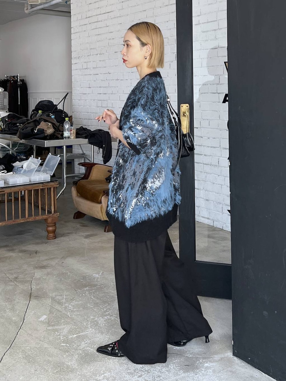 ブラック系のパンプス、ブルー系のカーディガン/ボレロ、ブラック系のショルダーバッグを着用したレディースの秋コーディネートの3枚目の写真