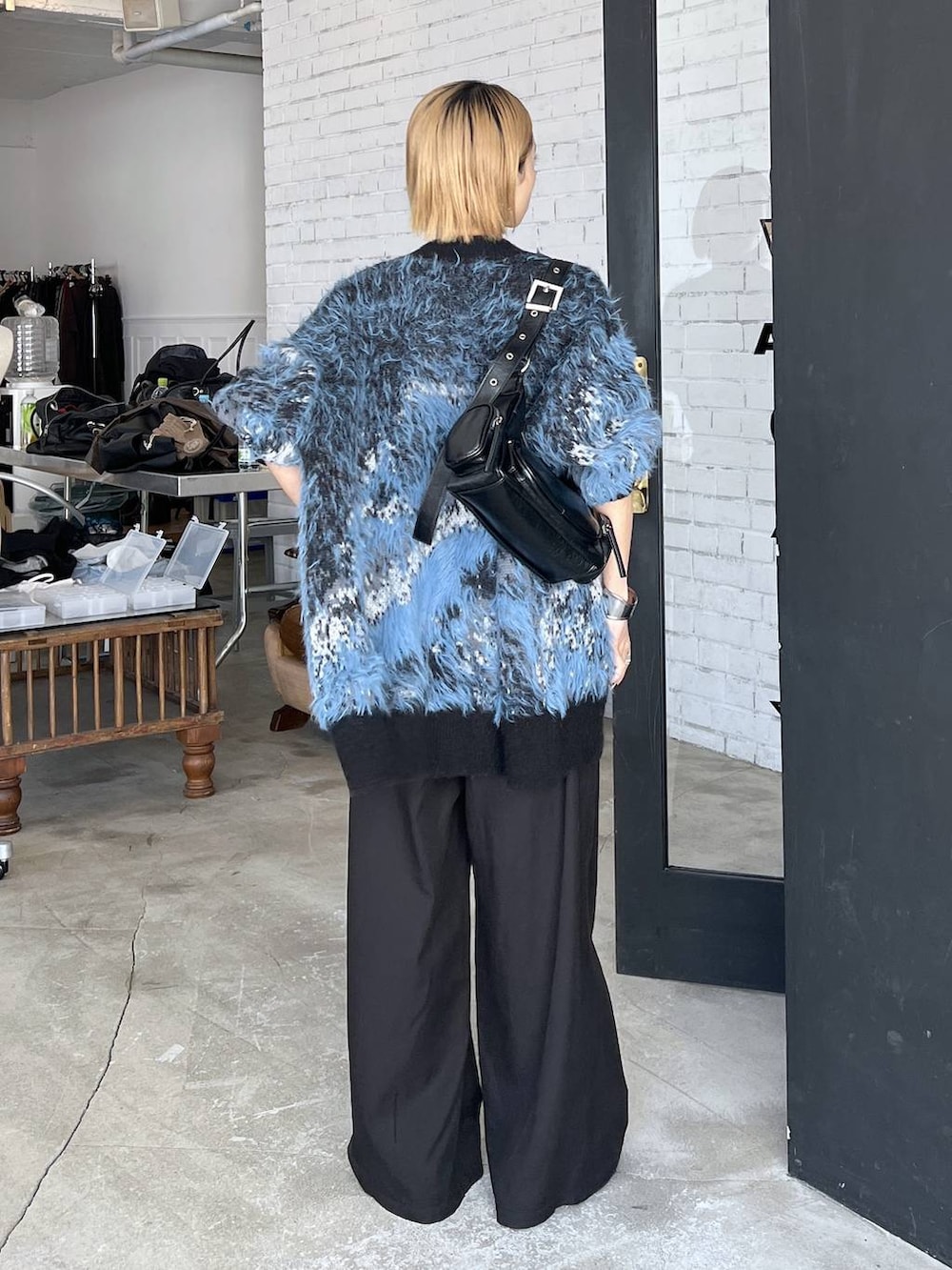 ブラック系のパンプス、ブルー系のカーディガン/ボレロ、ブラック系のショルダーバッグを着用したレディースの秋コーディネートの4枚目の写真