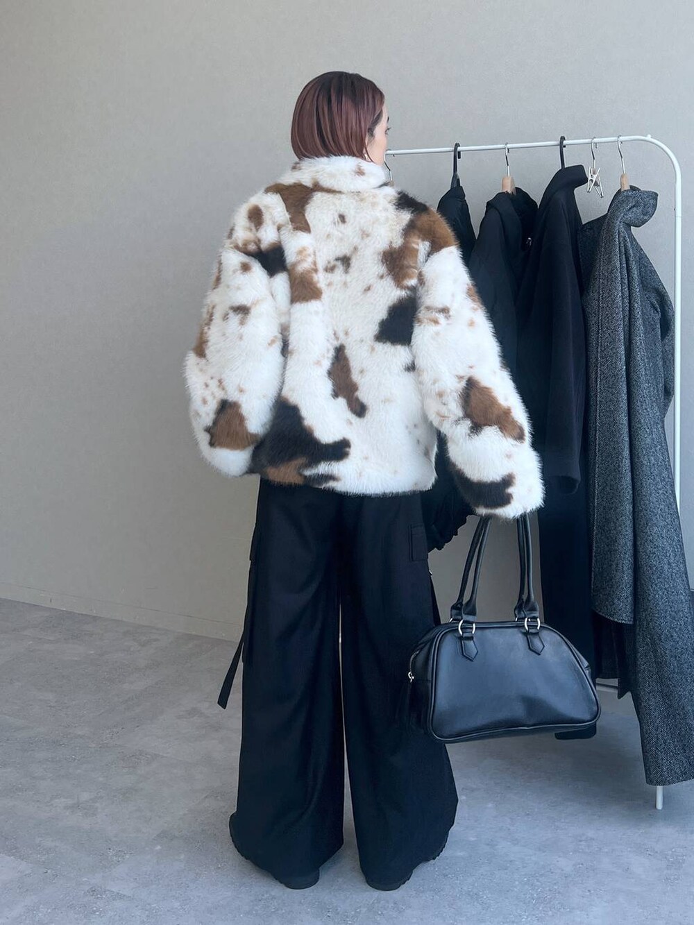 ブラック系のスラックス、ブラック系のボストンバッグを着用したレディースの秋コーディネートの4枚目の写真