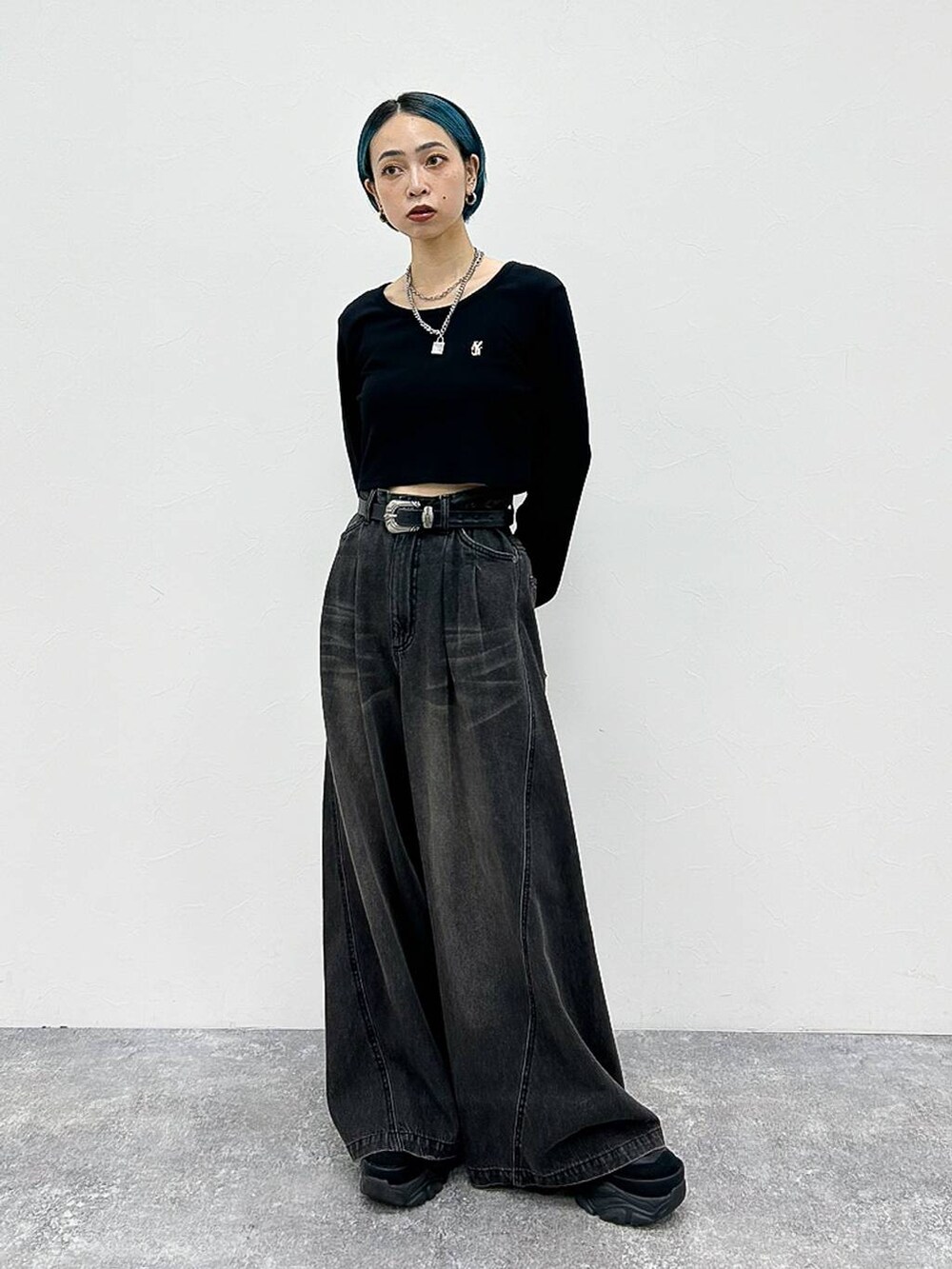 ブラック系のデニムパンツ、ブラック系のスニーカー、シルバー系のネックレスを着用したレディースの夏コーディネートの2枚目の写真