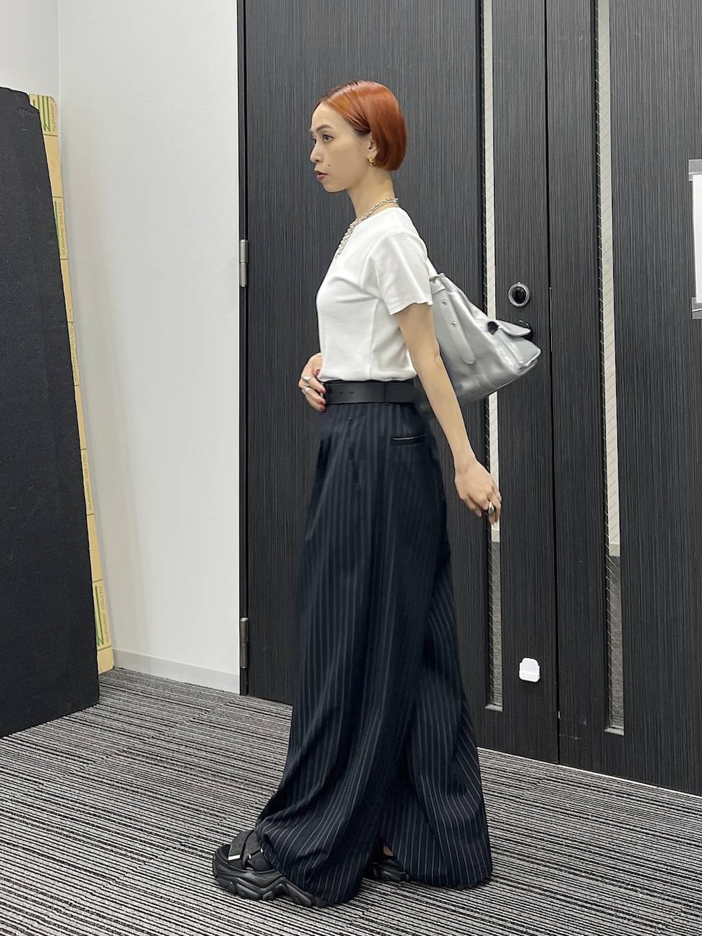 ブラック系のサンダル、シルバー系のハンドバッグ、ホワイト系のTシャツ/カットソーを着用したレディースの夏コーディネートの3枚目の写真