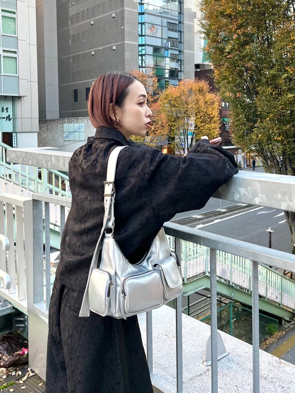 ブラック系のブーツ、シルバー系のショルダーバッグ、ブラック系のシャツ/ブラウスを着用したレディースの秋コーディネートの5枚目の写真