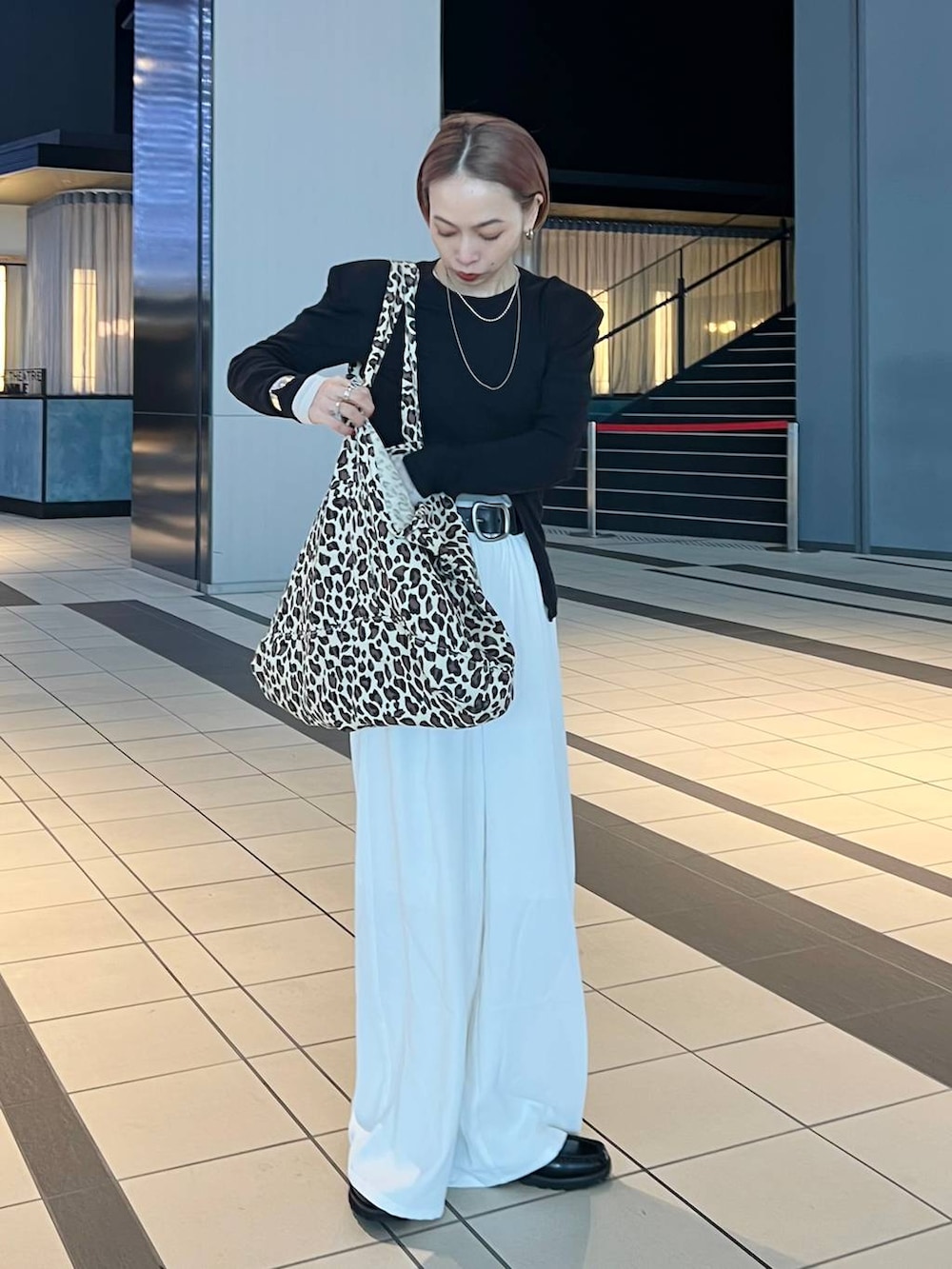 ホワイト系のスラックスを着用したレディースの冬コーディネートの2枚目の写真