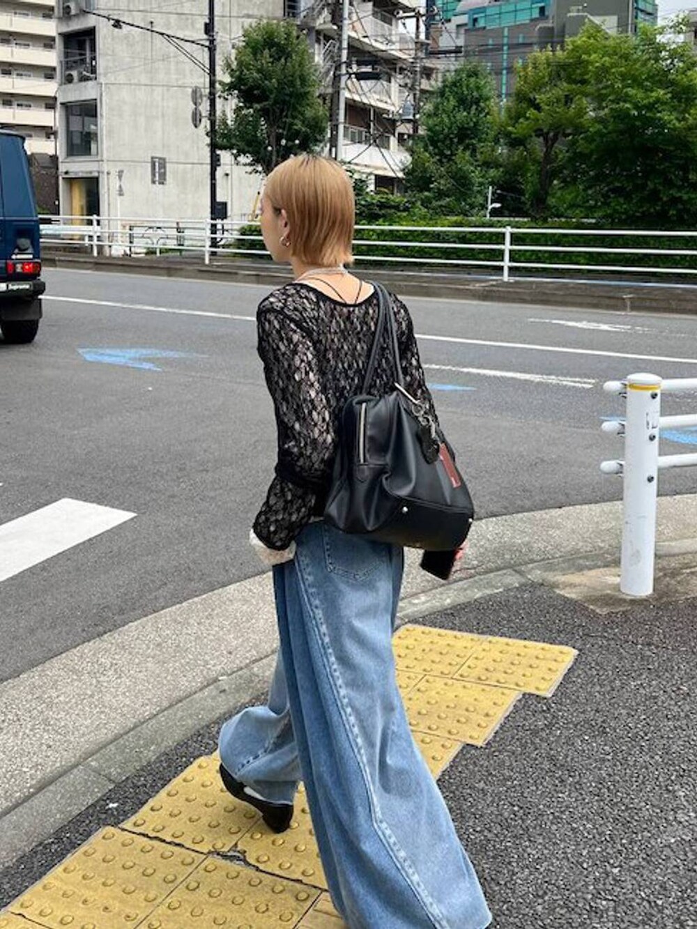 ブラック系のショルダーバッグ、ブルー系のデニムパンツ、ホワイト系のTシャツ/カットソーを着用したレディースの夏コーディネートの6枚目の写真