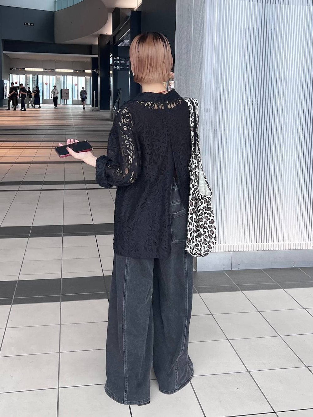 ブラック系のデニムパンツ、ブラック系のテーラードジャケット、ブラウン系のタンクトップを着用したレディースの夏コーディネートの6枚目の写真