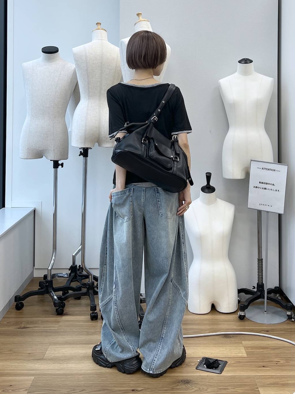 ブルー系のデニムパンツ、ブラック系のサンダル、ブラック系のボストンバッグを着用したレディースの春コーディネートの7枚目の写真