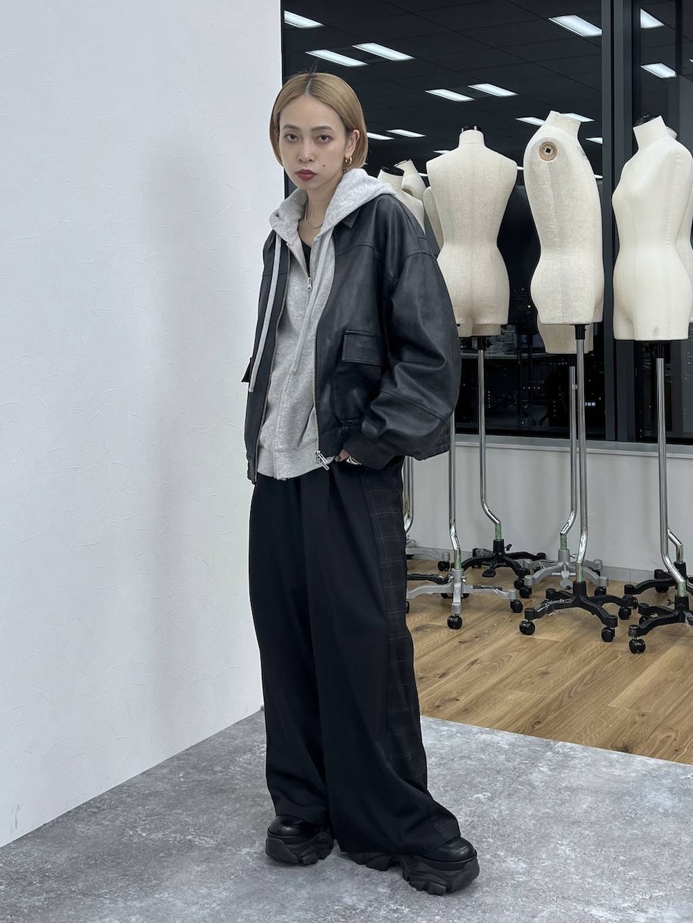 ブラック系のブーツ、ブラック系のスラックス、ブラック系のブルゾンを着用したレディースの秋コーディネートの4枚目の写真