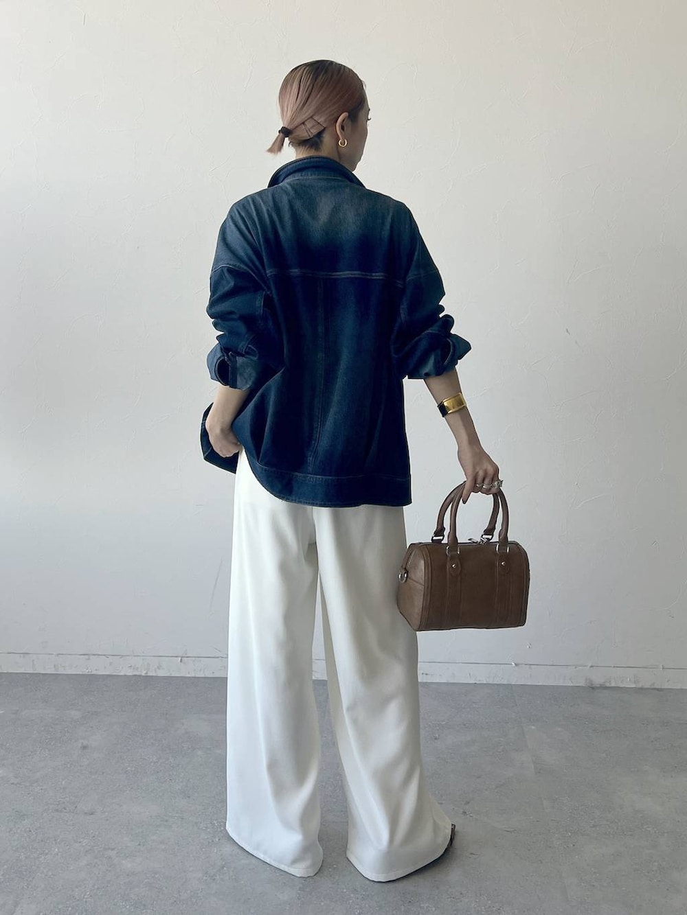 ブラウン系のボストンバッグ、ブルー系のブルゾン、グレー系のTシャツ/カットソーを着用したレディースの春コーディネートの6枚目の写真