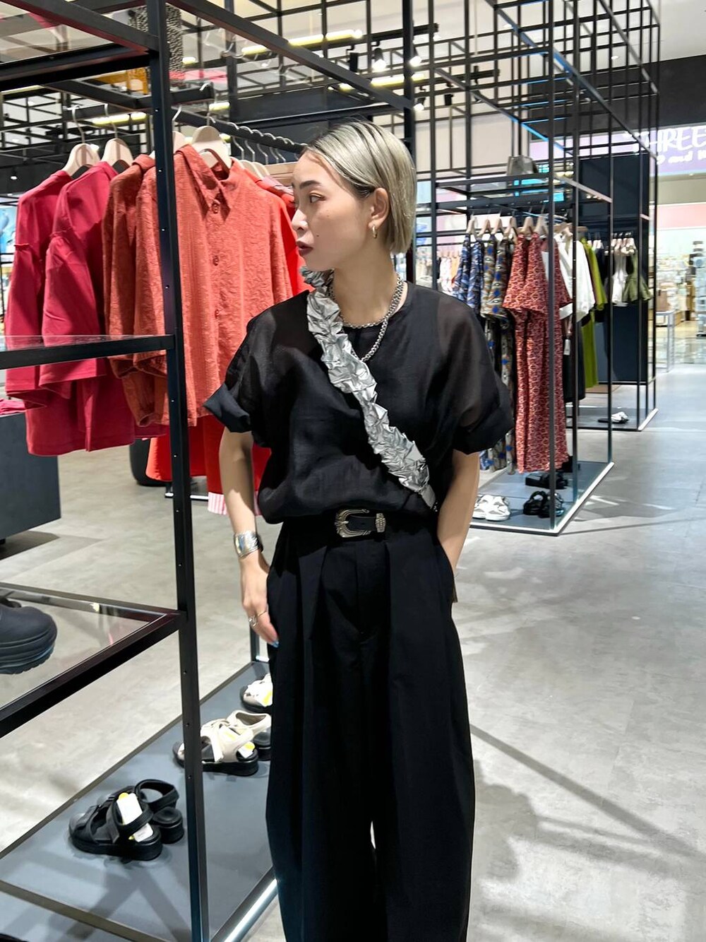 ブラック系のタンクトップ、ブラック系のスラックス、ブラック系のTシャツ/カットソーを着用したレディースの夏コーディネートの3枚目の写真