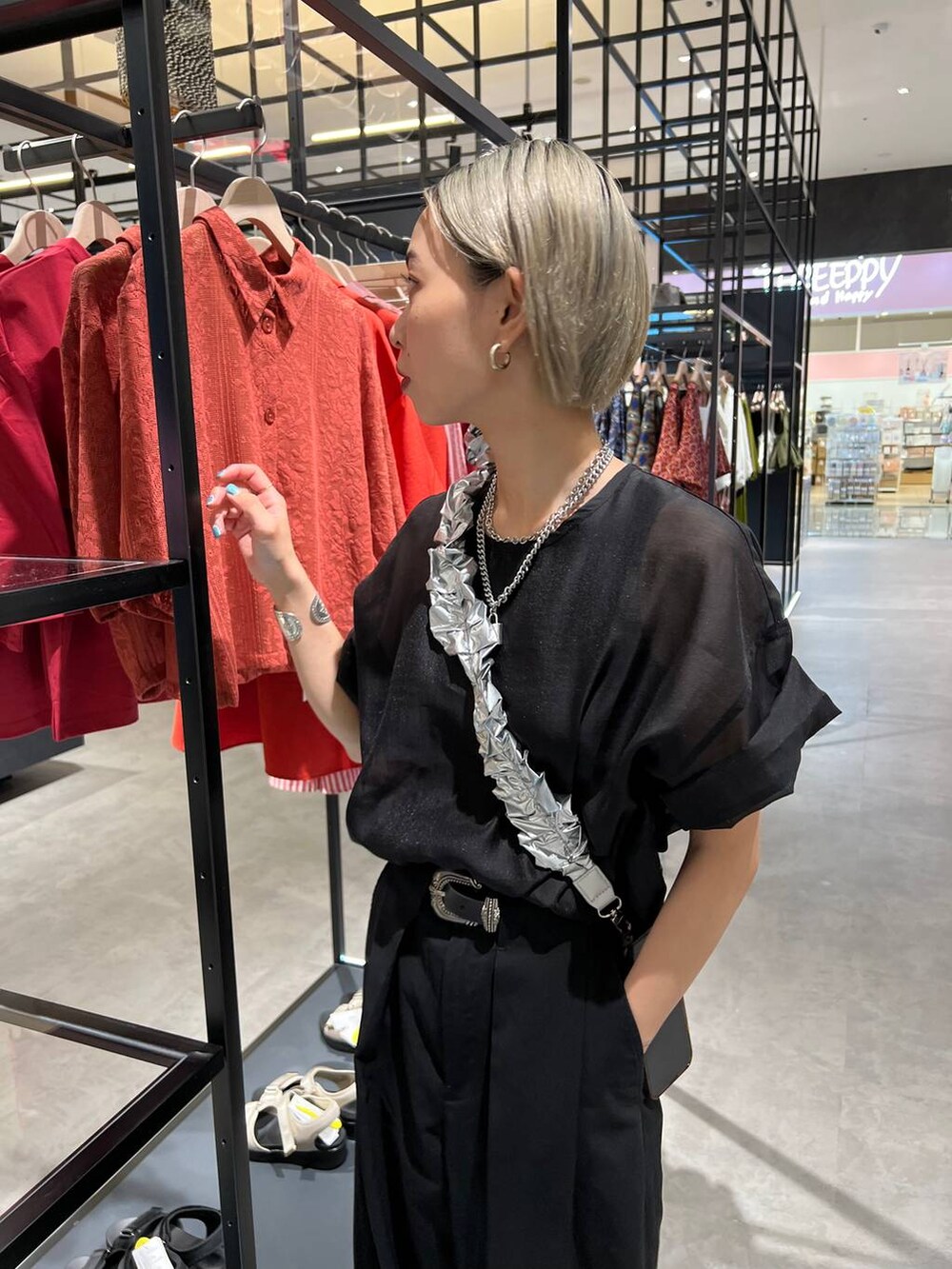 ブラック系のタンクトップ、ブラック系のスラックス、ブラック系のTシャツ/カットソーを着用したレディースの夏コーディネートの6枚目の写真