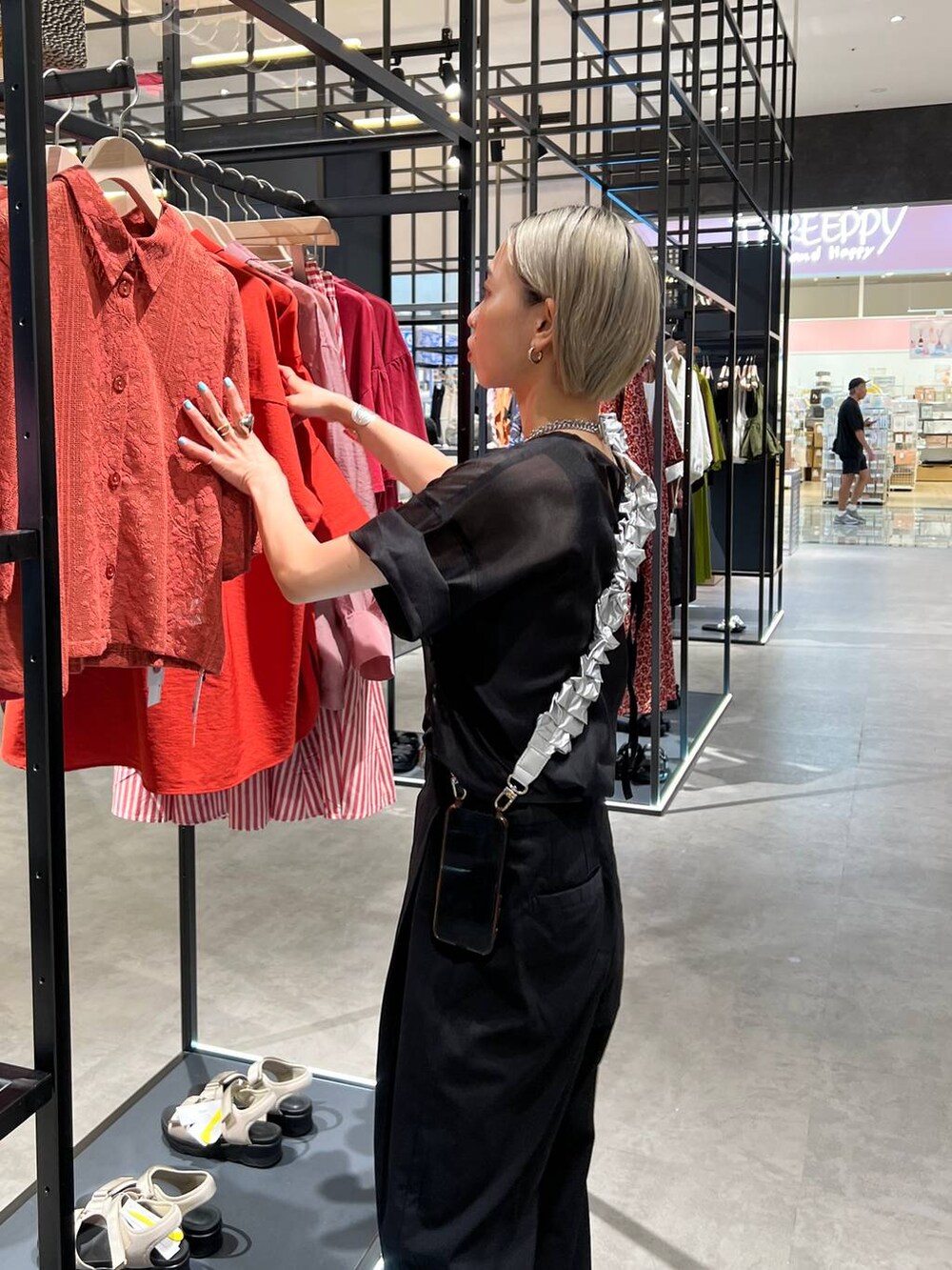 ブラック系のタンクトップ、ブラック系のスラックス、ブラック系のTシャツ/カットソーを着用したレディースの夏コーディネートの4枚目の写真