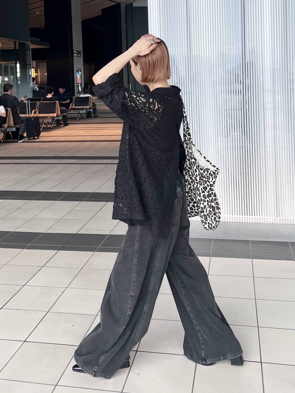 ブラック系のデニムパンツ、ブラック系のテーラードジャケット、ブラウン系のタンクトップを着用したレディースの夏コーディネートの4枚目の写真