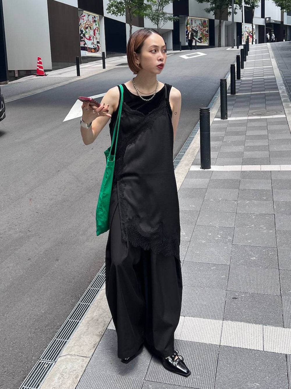 ブラック系のチュニック、ブラック系のスラックス、ブラック系のタンクトップを着用したレディースの夏コーディネートの5枚目の写真