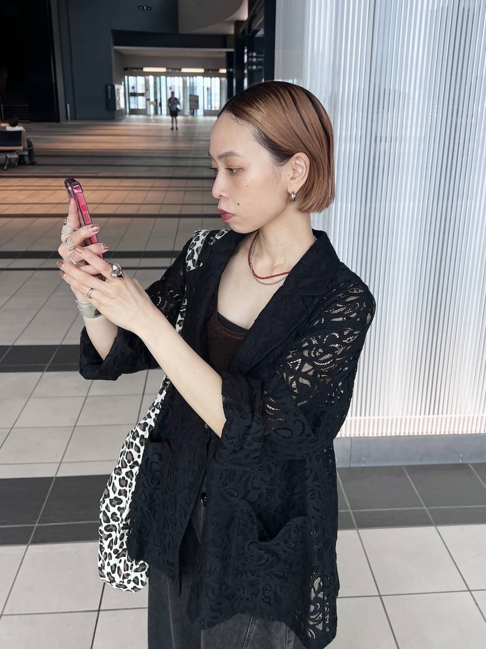 ブラック系のデニムパンツ、ブラック系のテーラードジャケット、ブラウン系のタンクトップを着用したレディースの夏コーディネートの3枚目の写真