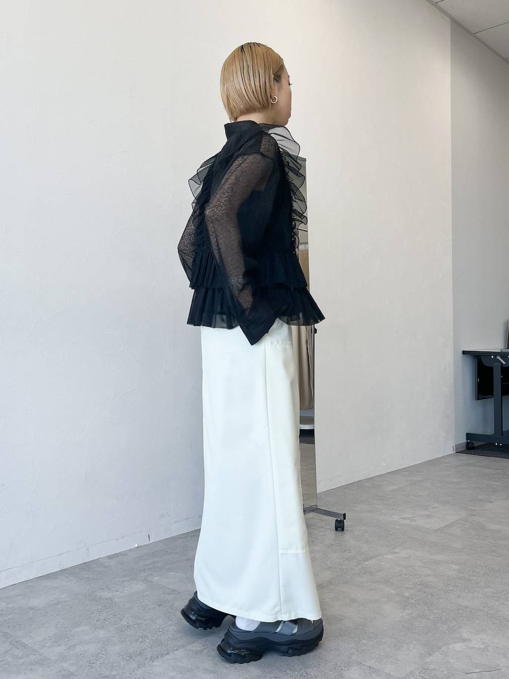 ブラック系のベスト、ブラック系のシャツ/ブラウス、ホワイト系のスカートを着用したレディースの春コーディネートの4枚目の写真