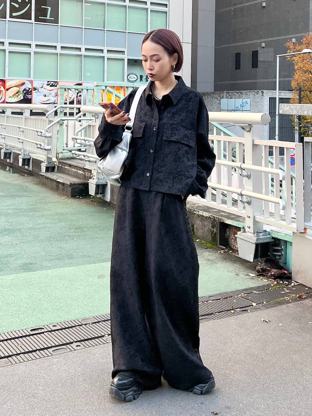 ブラック系のブーツ、シルバー系のショルダーバッグ、ブラック系のシャツ/ブラウスを着用したレディースの秋コーディネートの3枚目の写真