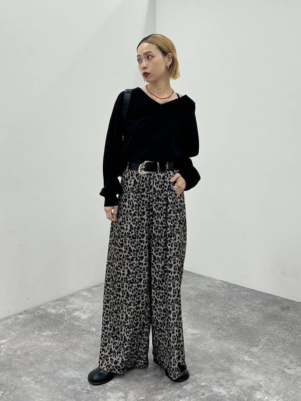 ブラック系のその他シューズ、ブラック系のニット/セーター、ブラック系のショルダーバッグを着用したレディースの秋コーディネートの2枚目の写真