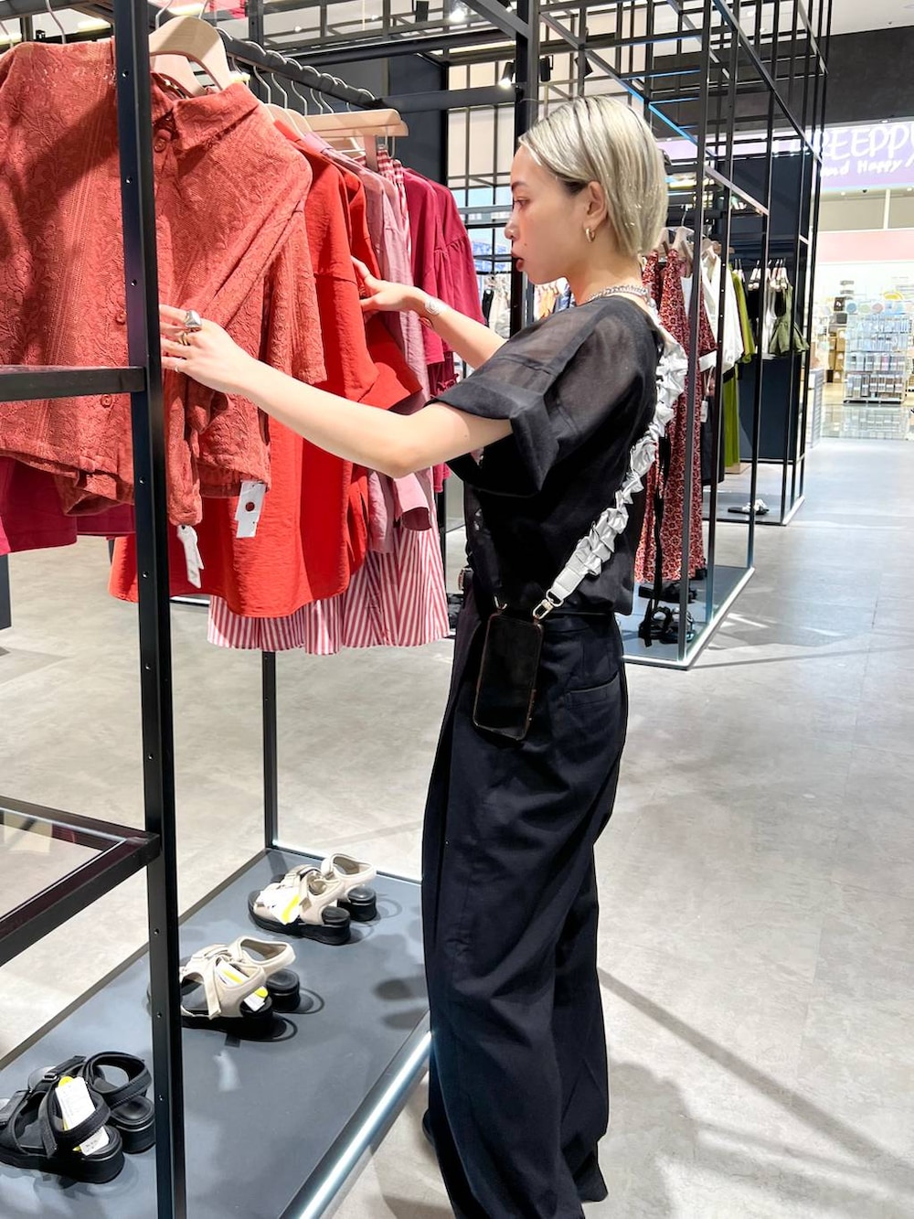 ブラック系のタンクトップ、ブラック系のスラックス、ブラック系のTシャツ/カットソーを着用したレディースの夏コーディネートの2枚目の写真