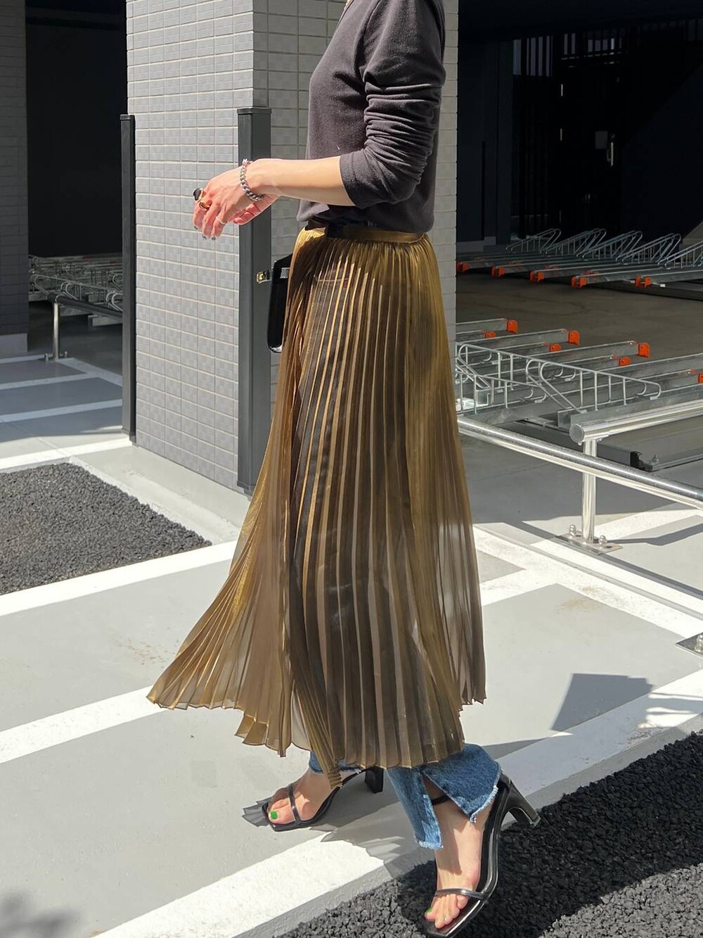 ゴールド系のスカートを着用したレディースの春コーディネートの4枚目の写真
