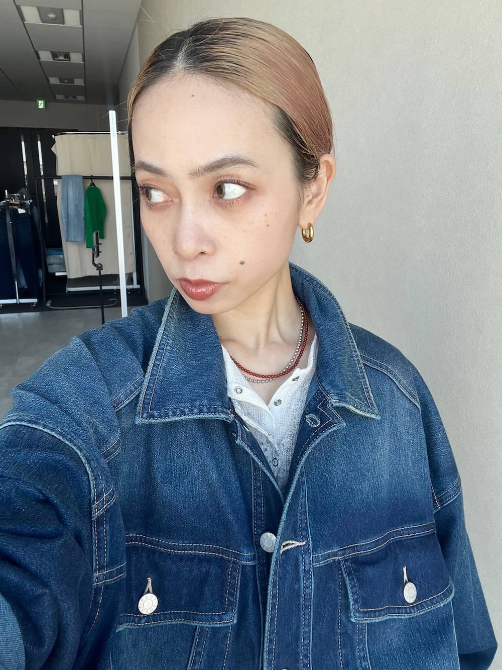 ブラウン系のボストンバッグ、ブルー系のブルゾン、グレー系のTシャツ/カットソーを着用したレディースの春コーディネートの2枚目の写真