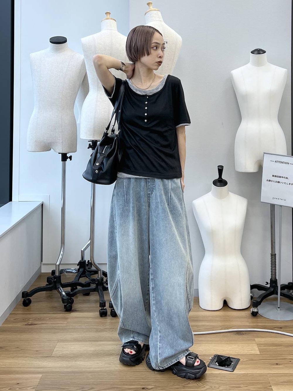 ブルー系のデニムパンツ、ブラック系のサンダル、ブラック系のボストンバッグを着用したレディースの春コーディネートの2枚目の写真