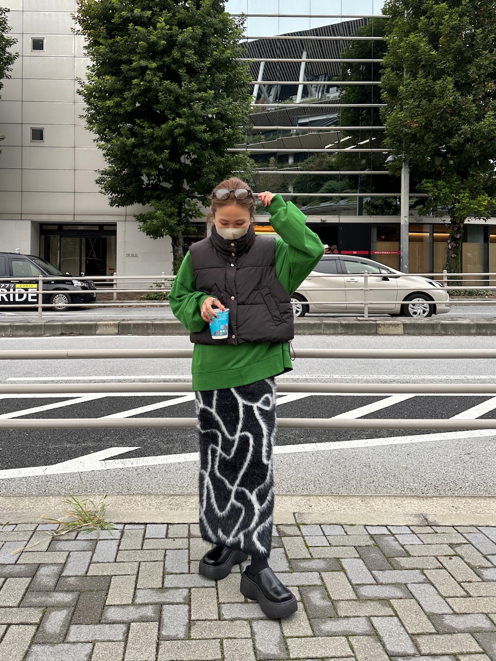 ブラック系のスカート、グリーン系のスウェット、ブラック系のブルゾンを着用したレディースの冬コーディネートの2枚目の写真