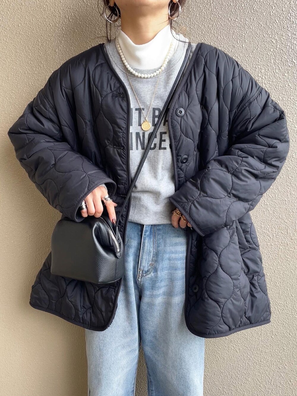 ブラック系のブルゾン、グレー系のスウェット、ブルー系のデニムパンツを着用したレディースの冬コーディネートの4枚目の写真