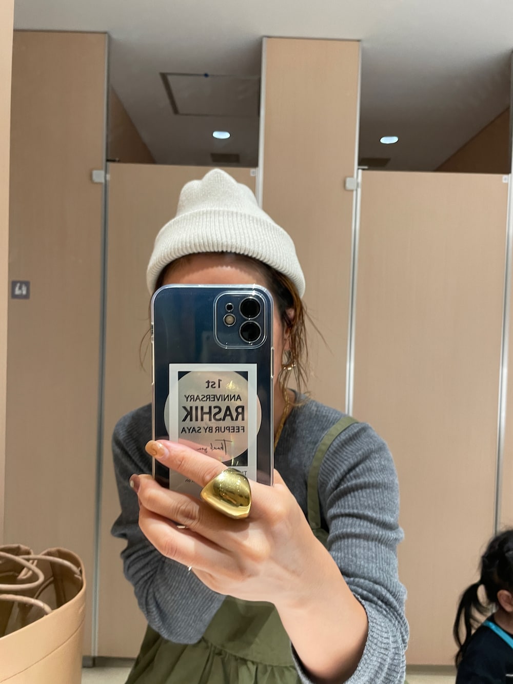 ブルー系のデニムパンツ、グレー系のニット/セーター、グリーン系のキャミソールを着用したレディースの秋コーディネートの4枚目の写真