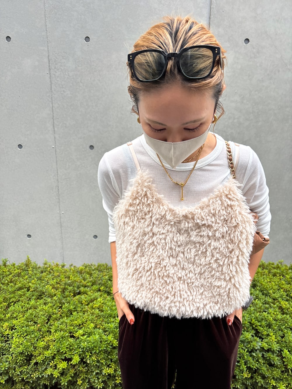 ホワイト系のベスト、ブラウン系のスニーカー、ブラウン系のパンツを着用したレディースの秋コーディネートの3枚目の写真