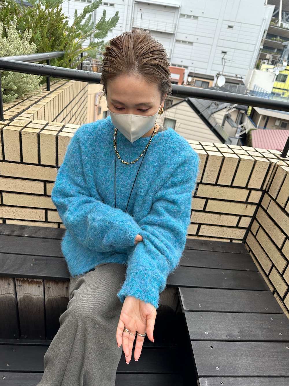 ホワイト系のモッズコート、ブルー系のニット/セーター、グレー系のワンピースを着用したレディースの冬コーディネートの4枚目の写真