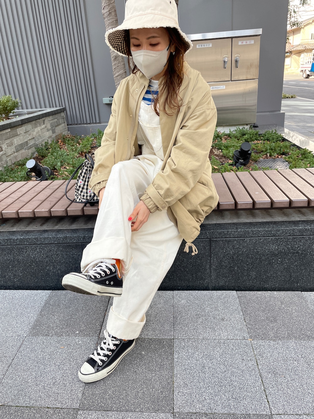 ブルー系のTシャツ/カットソー、ホワイト系のサロペット/オーバーオール、ベージュ系のミリタリージャケットを着用したレディースの春コーディネートの3枚目の写真