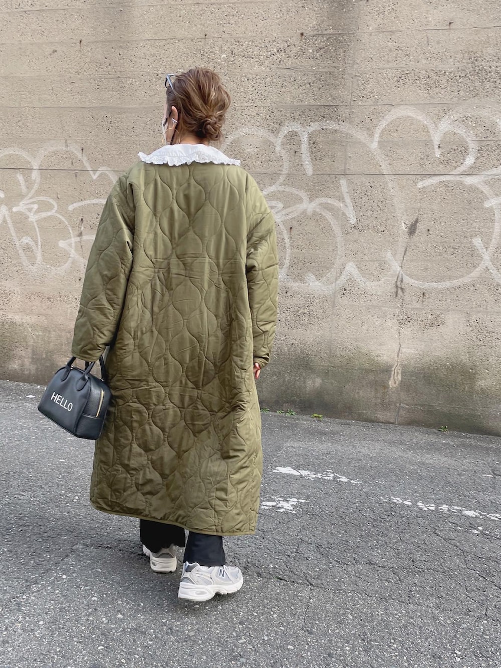 グレー系のスウェット、グリーン系のノーカラーコート、ブラック系のスラックスを着用したレディースの冬コーディネートの4枚目の写真