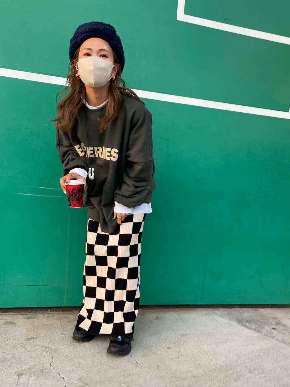 グリーン系のスウェット、ホワイト系のスカート、ブルー系のハットを着用したレディースの秋コーディネートの3枚目の写真