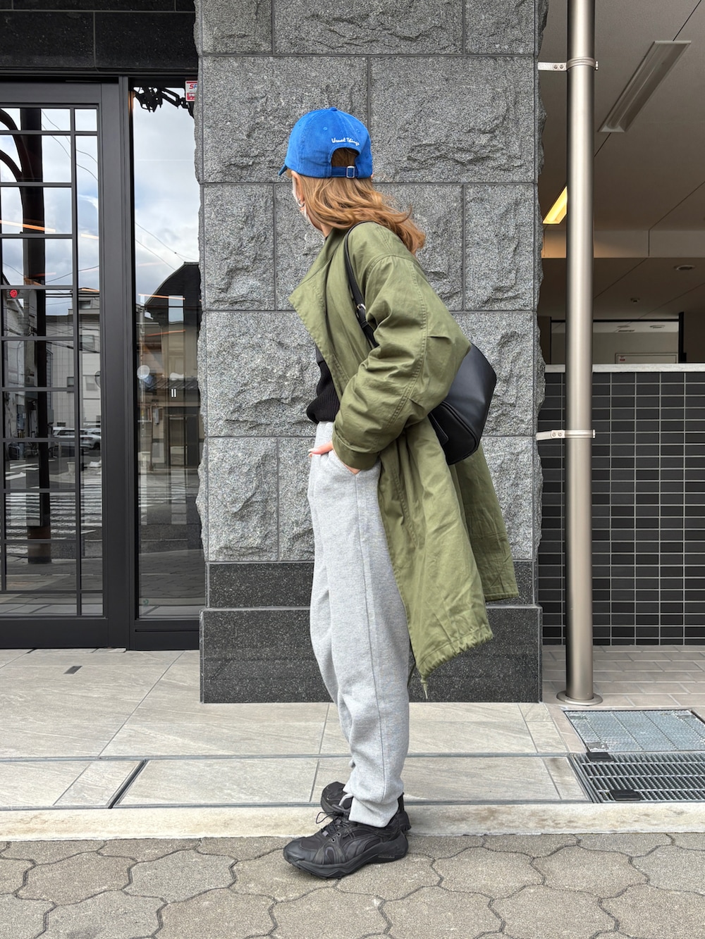 グリーン系のモッズコート、ブラック系のショルダーバッグ、グレー系のその他トップスを着用したレディースの冬コーディネートの2枚目の写真