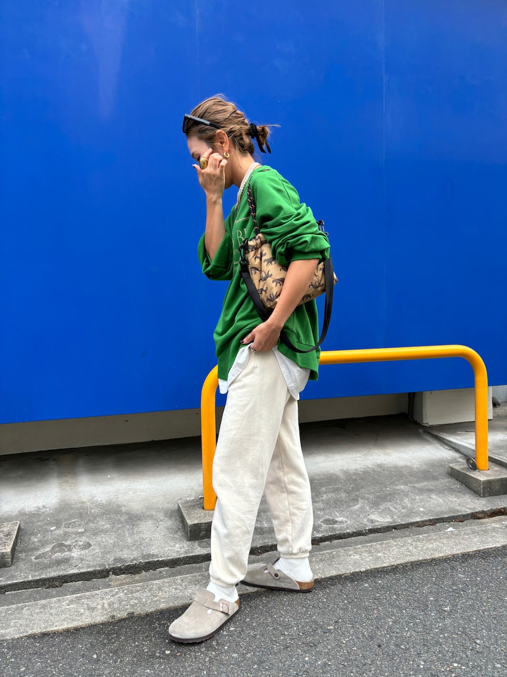 グリーン系のスウェット、ホワイト系のスウェットパンツを着用したレディースの秋コーディネートの2枚目の写真