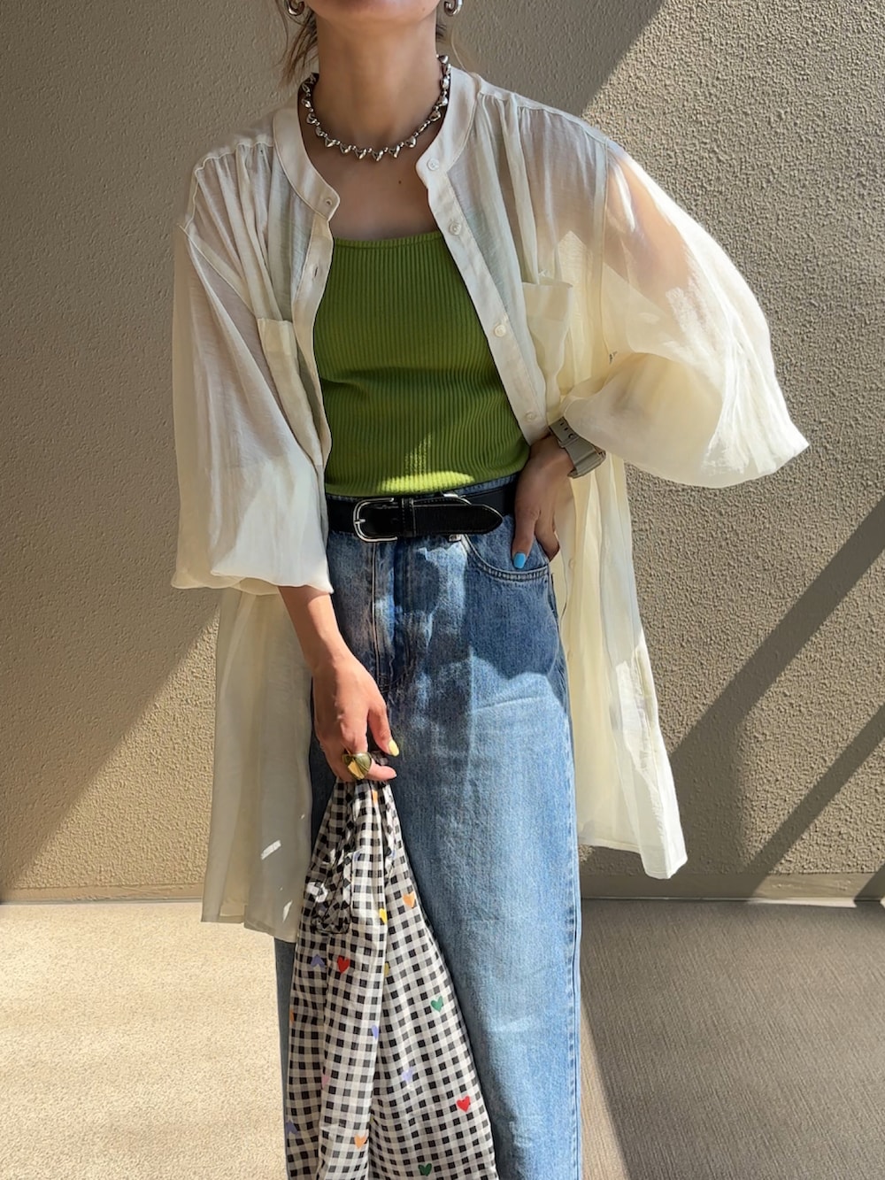 ホワイト系のシャツ/ブラウス、ブルー系のデニムスカート、ブラック系のサンダルを着用したレディースの春コーディネートの2枚目の写真