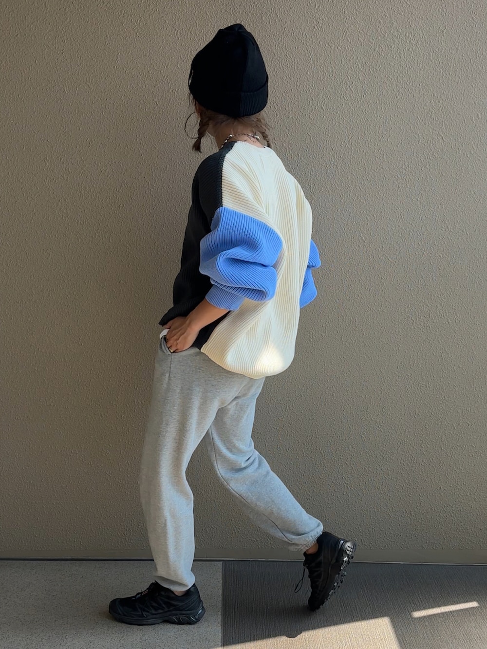 グレー系のニット/セーター、グレー系のスウェットパンツ、ブラック系のニットキャップ/ビーニーを着用したレディースの秋コーディネートの4枚目の写真