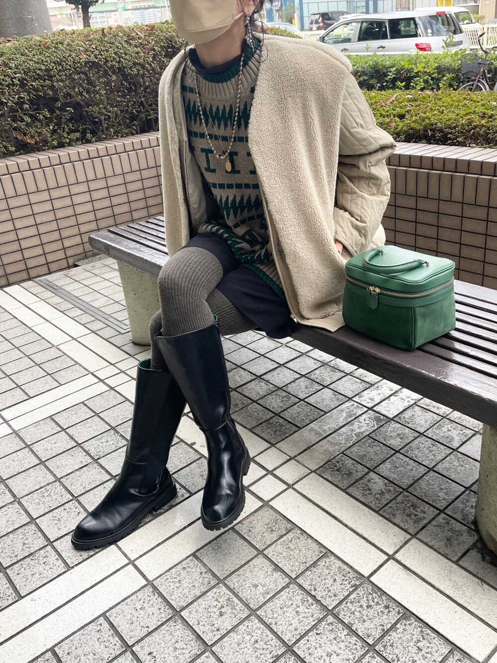 グリーン系のニット/セーター、ベージュ系のその他アウター、ブラック系のブーツを着用したレディースの冬コーディネートの2枚目の写真