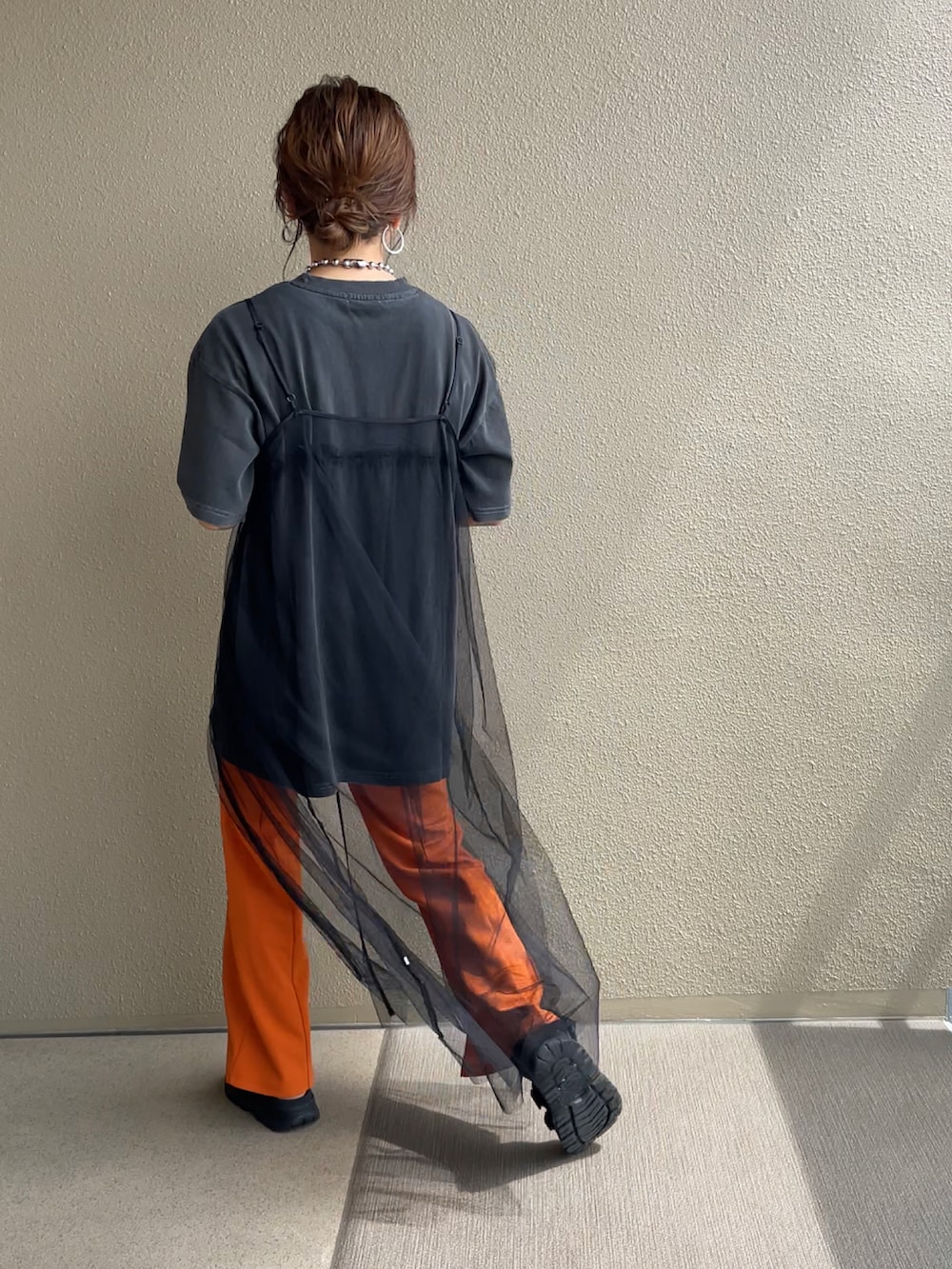 ブラック系のTシャツ/カットソー、オレンジ系のスラックス、ブラック系のワンピースを着用したレディースの夏コーディネートの4枚目の写真