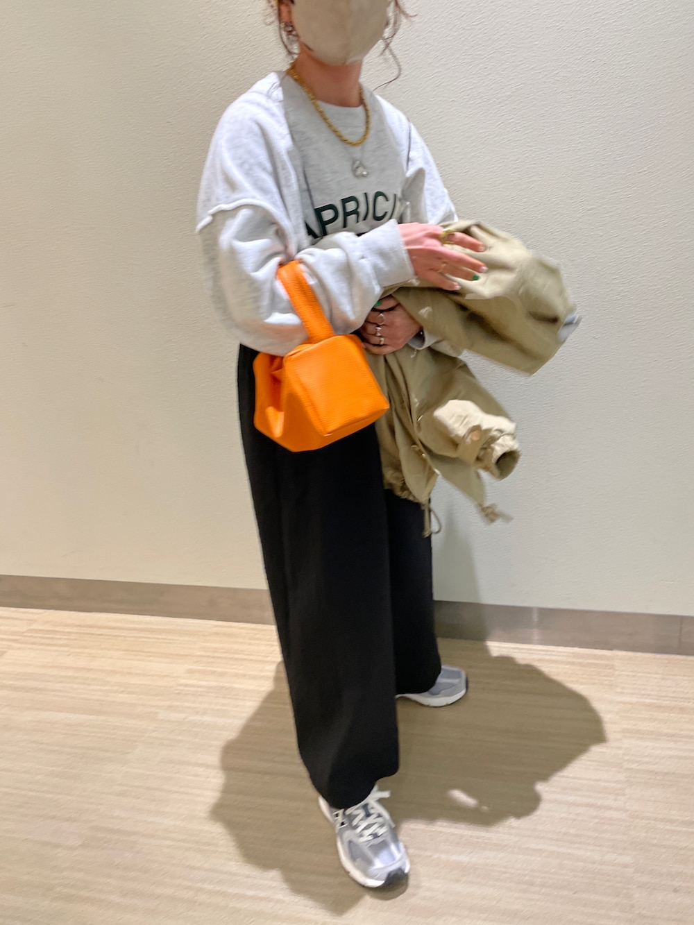 ベージュ系のミリタリージャケット、ベージュ系のスウェット、ブラック系のワンピースを着用したレディースの春コーディネートの4枚目の写真