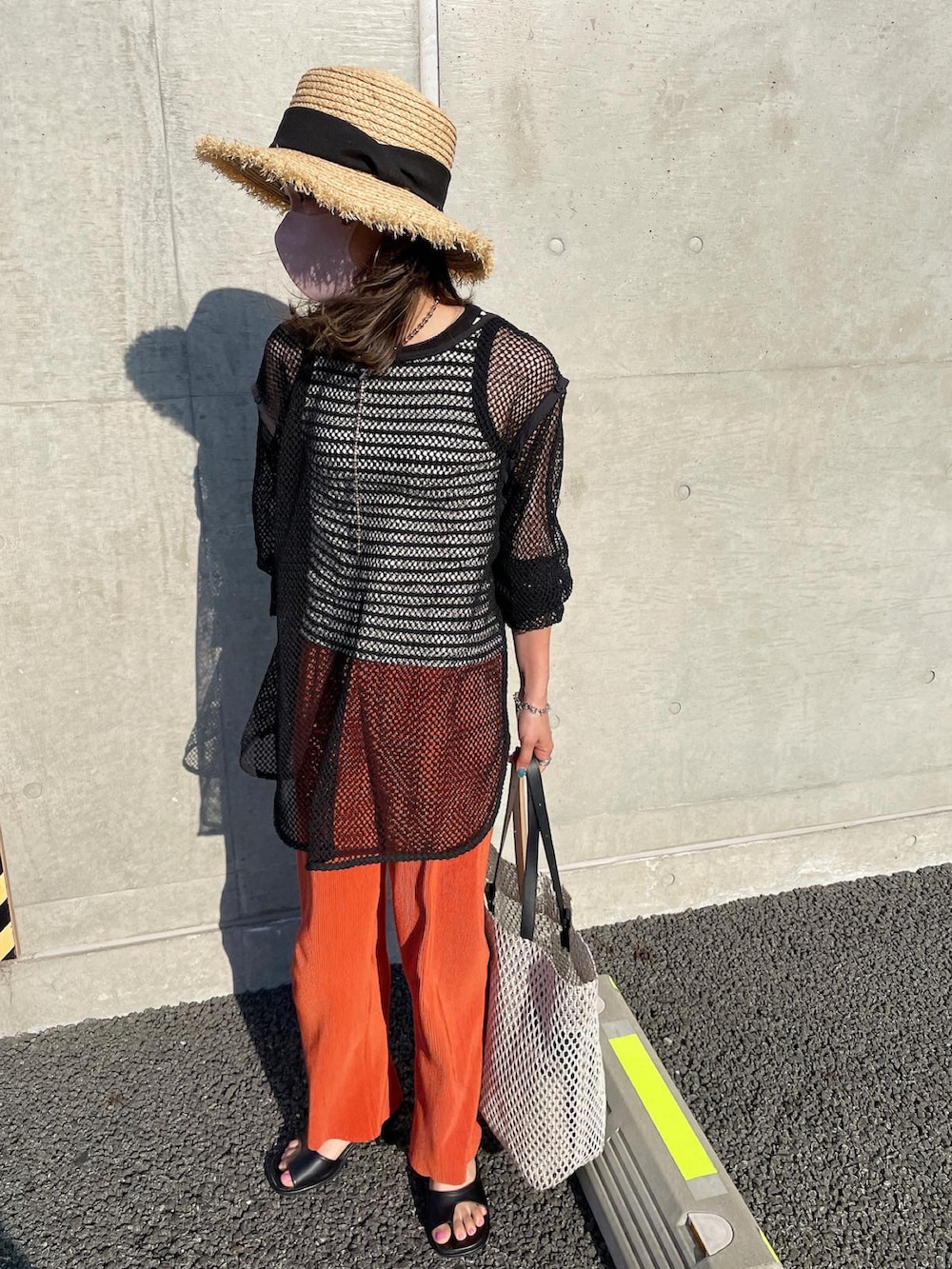 ブラック系のTシャツ/カットソー、オレンジ系のその他パンツ、その他のその他を着用したレディースの春コーディネートの3枚目の写真