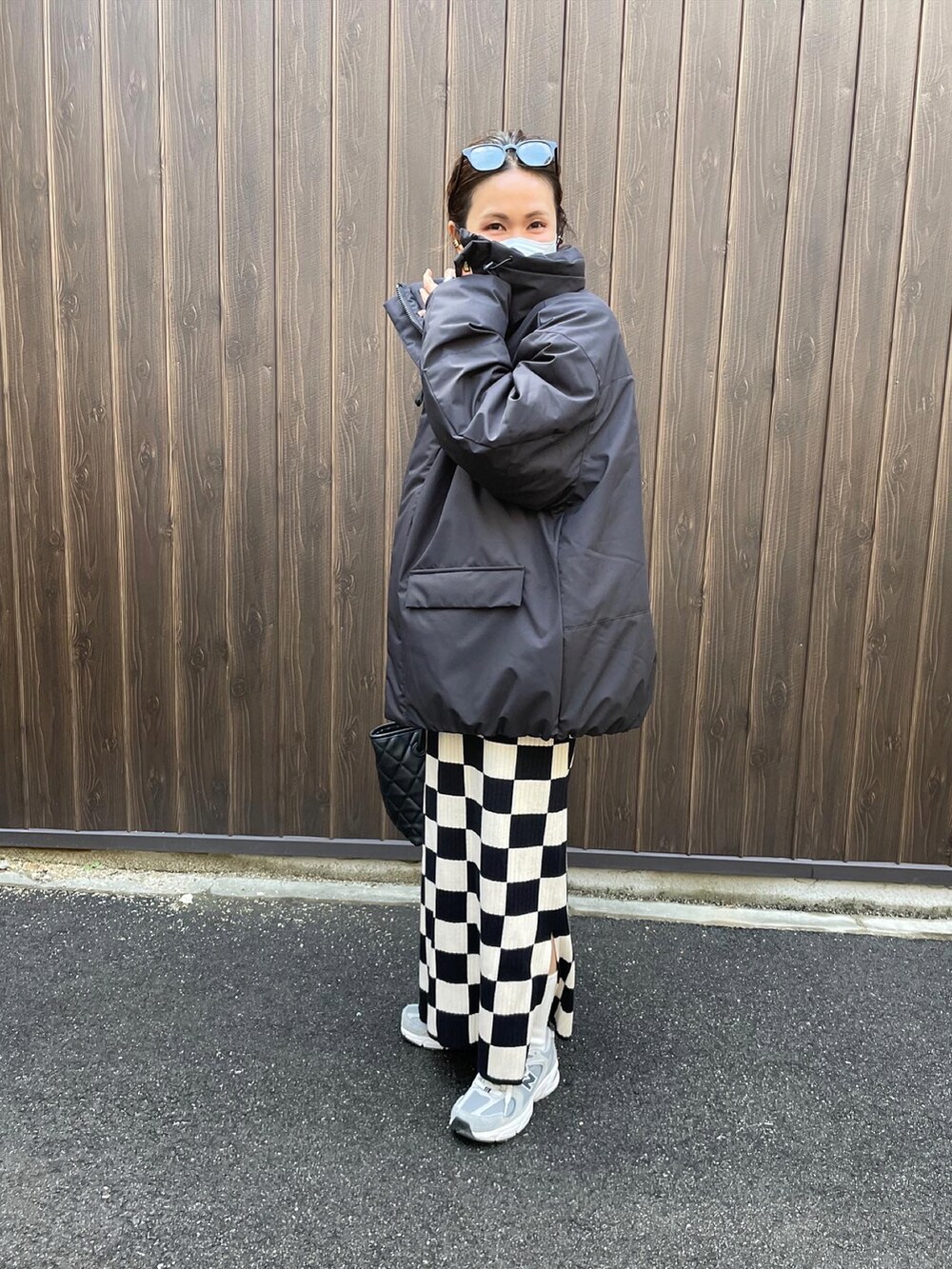 ブラック系のダウンジャケット/コート、ホワイト系のスカートを着用したレディースの冬コーディネートの3枚目の写真