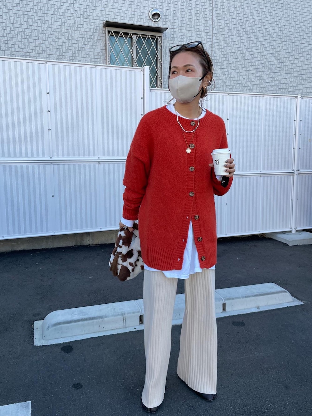 オレンジ系のカーディガン/ボレロ、ホワイト系のTシャツ/カットソー、ベージュ系のその他パンツを着用したレディースの冬コーディネートの3枚目の写真