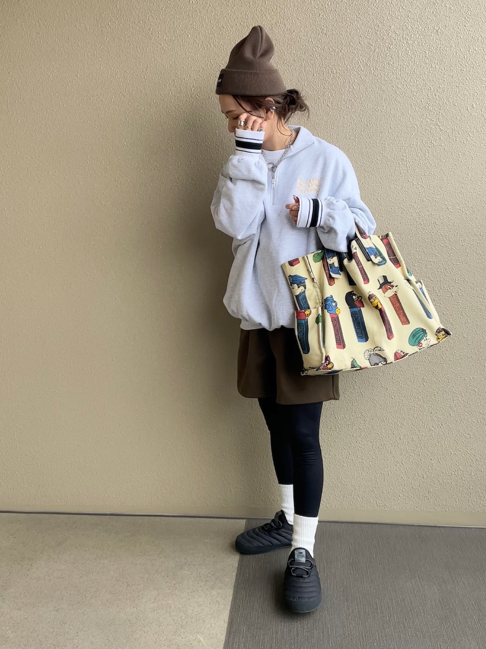 ベージュ系のスウェット、ブラウン系のパンツ、ホワイト系のトートバッグを着用したレディースの冬コーディネートの3枚目の写真