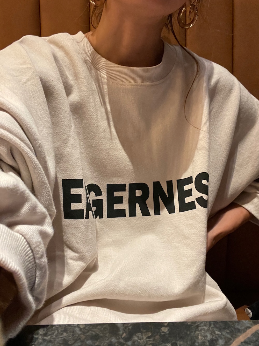 ホワイト系のスカート、ホワイト系のスウェット、シルバー系のバッグを着用したレディースの秋コーディネートの5枚目の写真