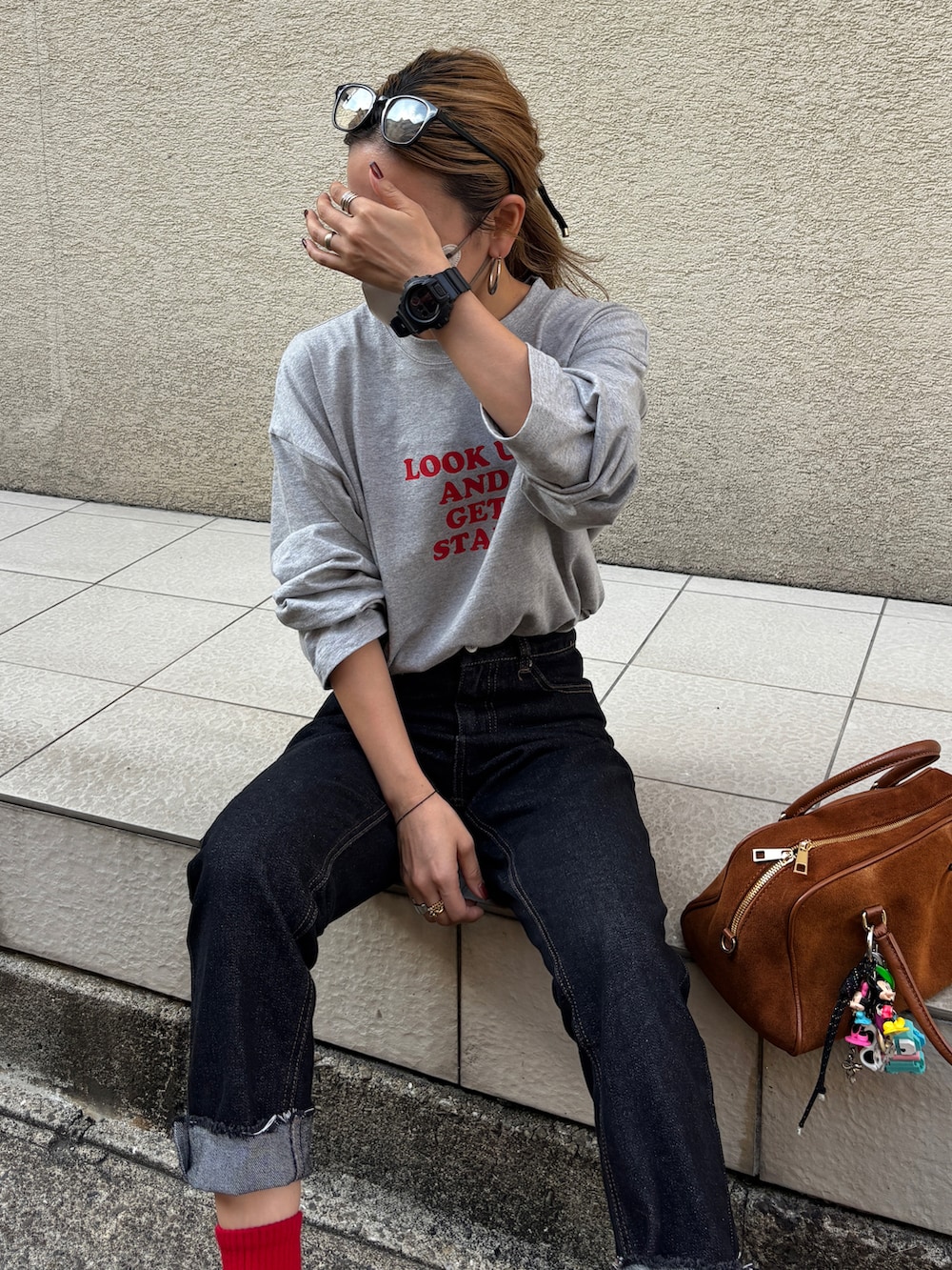 ブラック系のデニムパンツ、その他のスニーカー、グレー系のTシャツ/カットソーを着用したレディースの秋コーディネートの3枚目の写真